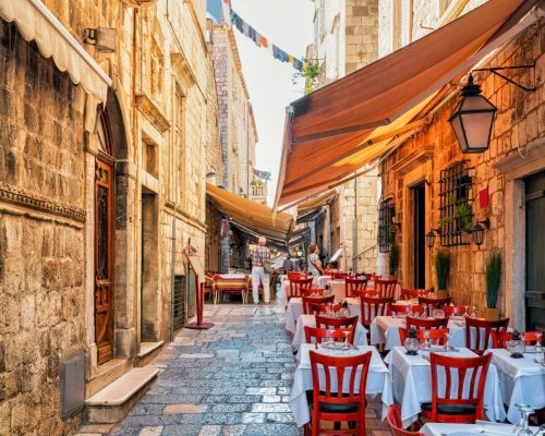 Street terraced cafe in the Old city in Dubrovnik, in Croatia. People on the background