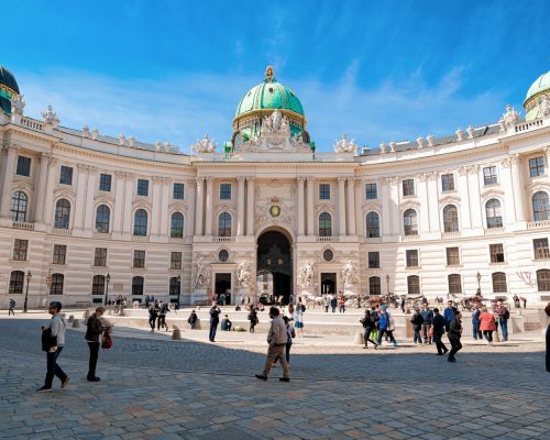 Vienna, Austria - May 8, 2019: People at St. Michael Wing of Hofburg Palace on Michaelerplatz in Innere Stadt in Vienna in Austria. Wien in Europe. Panorama, cityscape. Travel and tourism view