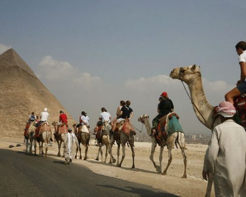 MAN15 EL CAIRO (EGIPTO), 11/10/2008.- Un grupo de turistas disfruta de una excursión en camello al pie de las pirámides de Giza, a las afueras de El Cairo, Egipto, hoy, sábado 11 de octubre. EFE/Mike Nelson. 

 EGIPTO - TURISMO - PIRÁMIDES EGIPTO - TURISMO - PIRÁMIDES