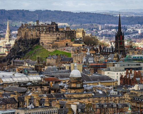 A view of Edinburgh city, castle, cathedral, and mountains from Arthur's Seat in Holyrood park.