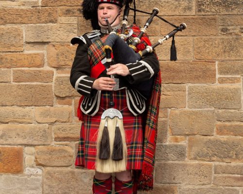 A man in Scottish national dress plays the national instrument in Edinburgh, Scotland May 2022