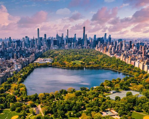 A Central Park in Manhattan, New York, a huge beautiful park surrounded by skyscraper with a pond