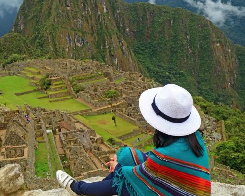 Female Relaxing on the Cliff Looking at Machu Picchu Inca Ruins, Cusco, Urubamba, Archaeological site in Peru, South America