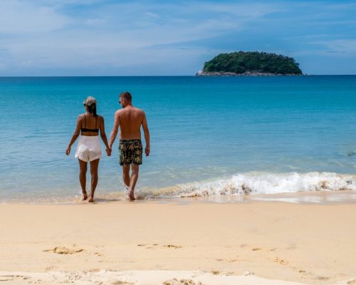 Kata Beach Phuket Thailand, a tropical beach with white golden sand and palm trees in Thailand. Couple man and woman mid age on vacation