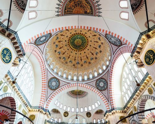 Interior view of the Suleymaniye Mosque with lightning and painted walls and ceiling in Istanbul, Turkey