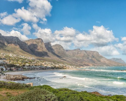 CAPE TOWN, SOUTH AFRICA, AUGUST 17, 2018: A view of the coastline in Camps Bay in Cape Town in the Western Cape Province. The 12 Apostles and buildings are visible