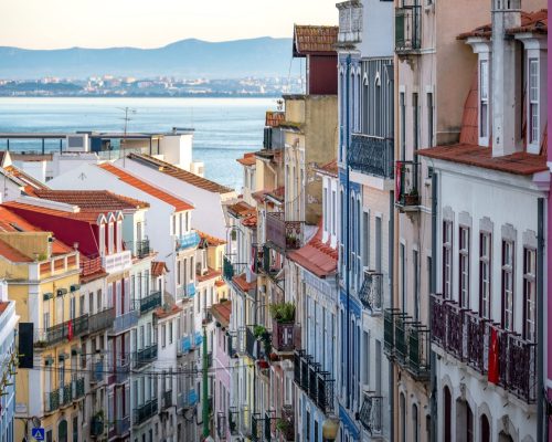 Dramatic view of colorful historic buildings in Lisbon, Portugal with the Tagus River in the background