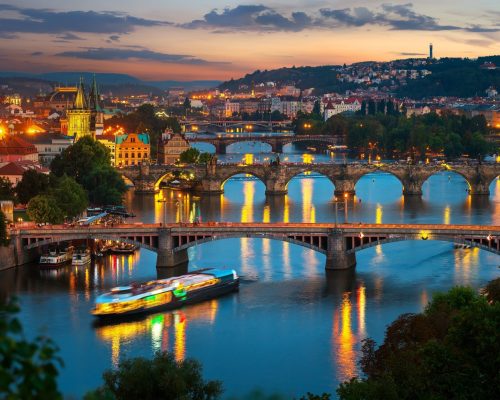 Illuminated bridges in Prague on river Vltava at sunset