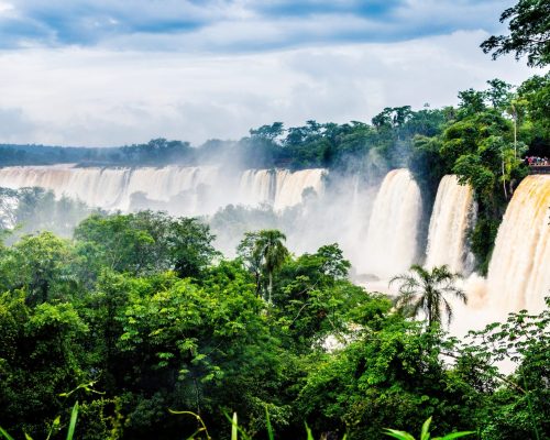 The waterfall at Iguazu National Park surrounded by forests covered in the fog under a cloudy sky